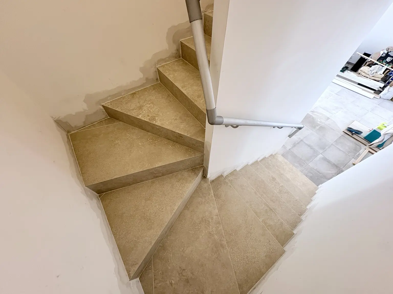 Escalier tournant rénové en carrelage imitation travertin à Mouriès
