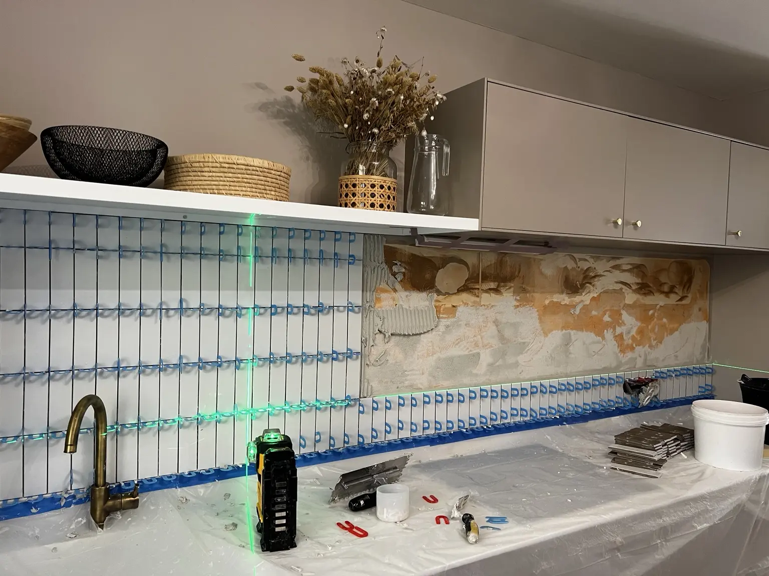 Pose au laser d’une faïence verticale 5 par 15 dans une cuisine