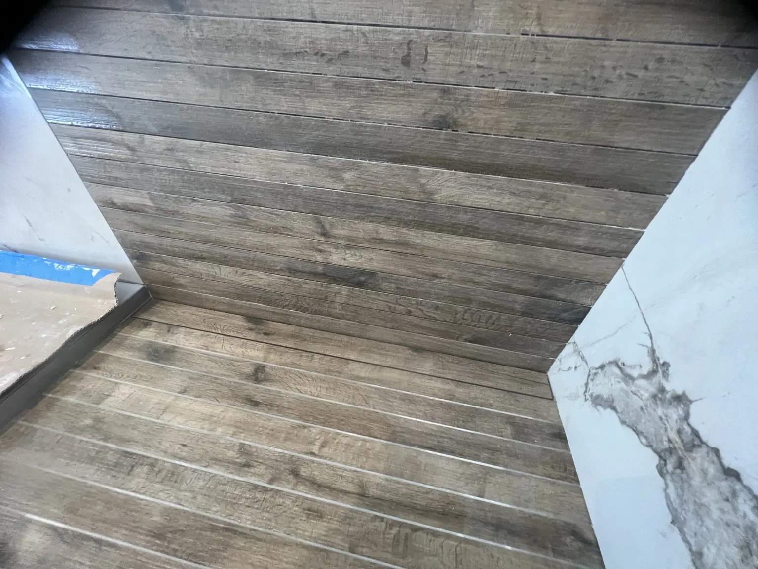 Détail de la pose du carrelage imitation bois dans la douche